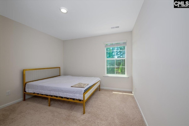 carpeted bedroom with visible vents and baseboards