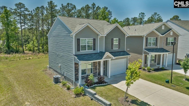 traditional-style home featuring central AC unit, an attached garage, driveway, and a front yard