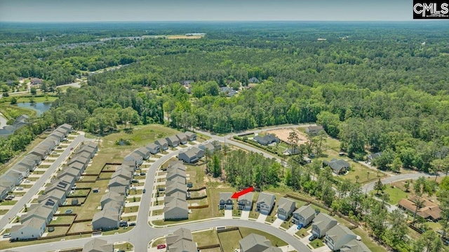 drone / aerial view featuring a forest view, a water view, and a residential view