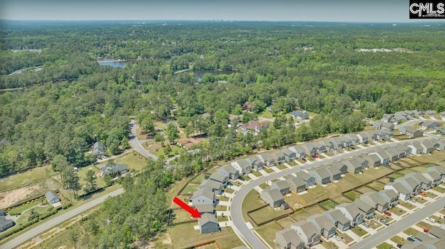 bird's eye view featuring a water view, a residential view, and a wooded view