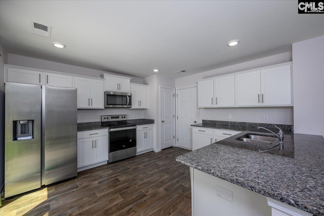 kitchen featuring a sink, white cabinets, stainless steel appliances, and dark wood finished floors
