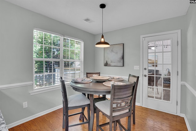 dining space with baseboards, visible vents, and light wood-type flooring