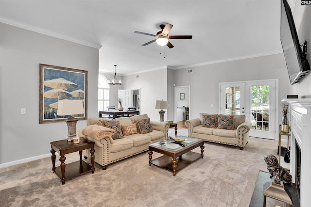 living area featuring crown molding, a fireplace, baseboards, carpet flooring, and ceiling fan with notable chandelier