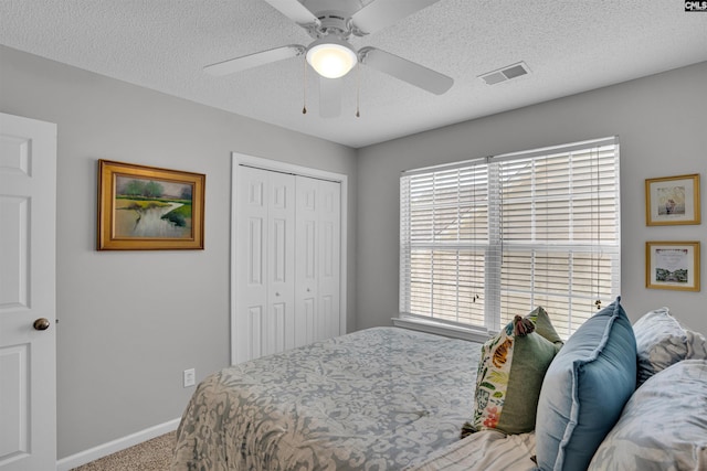 bedroom featuring carpet floors, visible vents, a closet, baseboards, and a ceiling fan