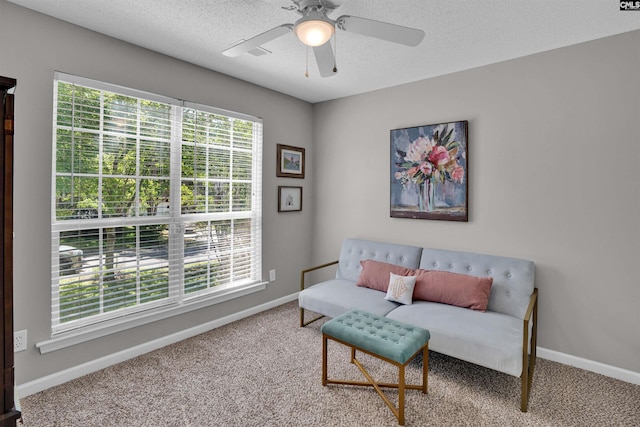 sitting room featuring carpet floors, a textured ceiling, baseboards, and ceiling fan
