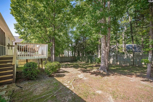 view of yard with fence, a wooden deck, and stairs