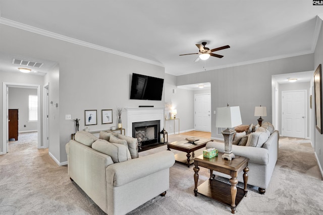 living area with visible vents, crown molding, a fireplace, baseboards, and a ceiling fan
