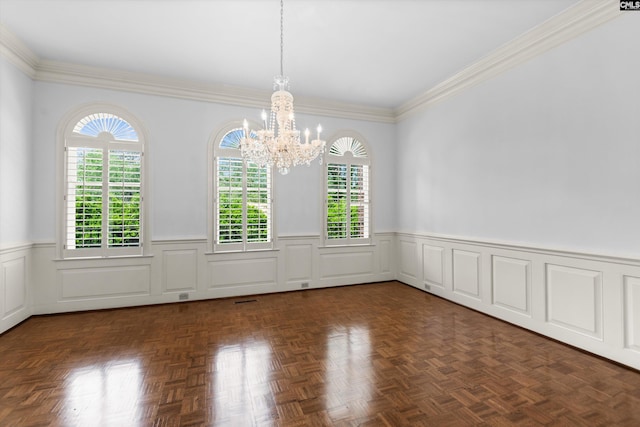 unfurnished dining area featuring crown molding, an inviting chandelier, wainscoting, and a healthy amount of sunlight