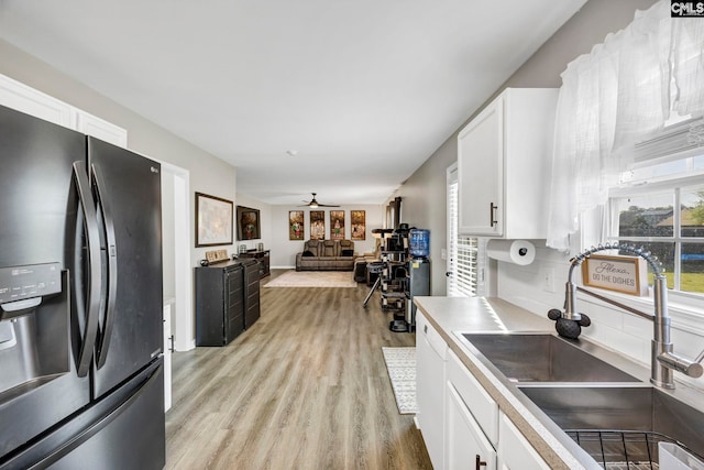 kitchen featuring white cabinets, a ceiling fan, light wood finished floors, and fridge with ice dispenser