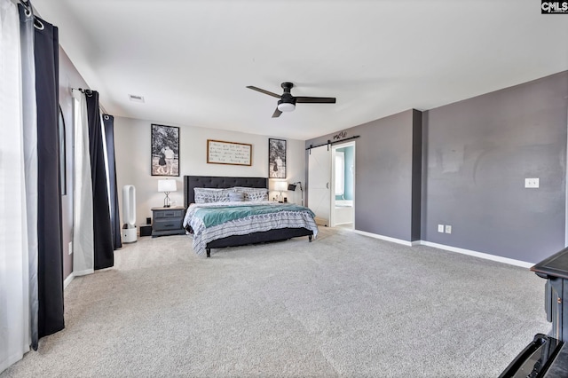 bedroom featuring baseboards, carpet flooring, a barn door, and visible vents