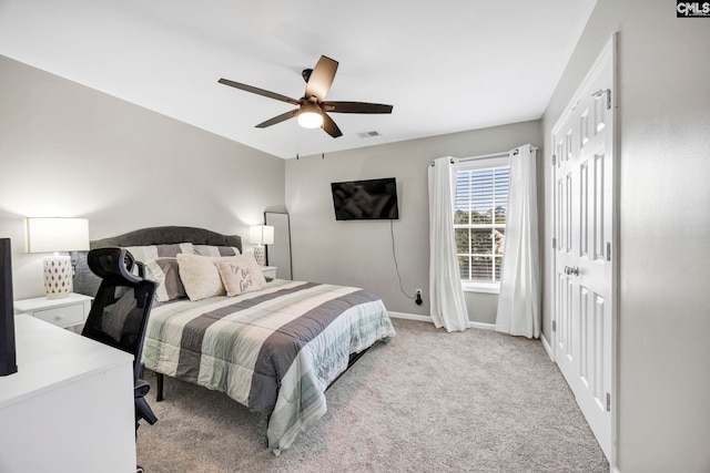 bedroom featuring visible vents, a closet, baseboards, ceiling fan, and light colored carpet