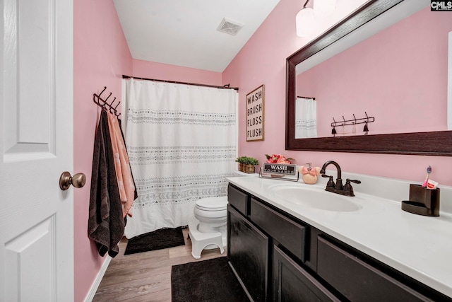 full bathroom featuring visible vents, wood finished floors, vanity, baseboards, and toilet