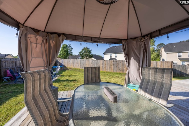wooden terrace with a gazebo, a fenced backyard, a yard, and outdoor dining space