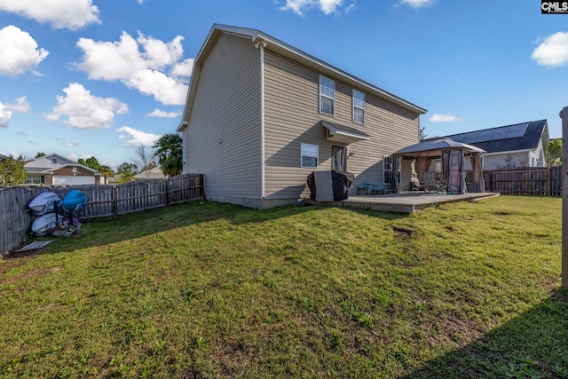back of house featuring a gazebo, a fenced backyard, a lawn, and a deck