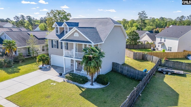 exterior space featuring a residential view, a garage, a front yard, covered porch, and driveway