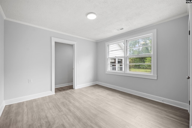 unfurnished bedroom featuring crown molding, a textured ceiling, visible vents, and wood finished floors