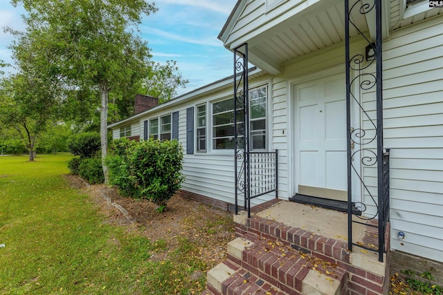 property entrance featuring a yard and a chimney