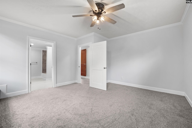 unfurnished bedroom with baseboards, ornamental molding, ensuite bathroom, and carpet