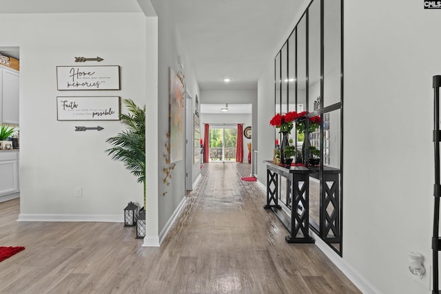 corridor with baseboards, recessed lighting, and wood finished floors