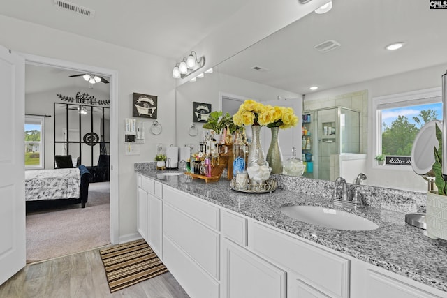 bathroom featuring visible vents, a sink, a stall shower, and a healthy amount of sunlight