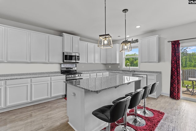 kitchen featuring a sink, white cabinets, light wood-style floors, stainless steel appliances, and recessed lighting