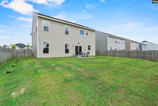 back of house with a lawn, a fenced backyard, and a patio area