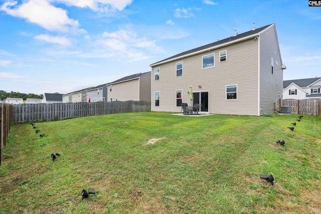 back of house featuring a fenced backyard, a patio area, a yard, and central AC unit