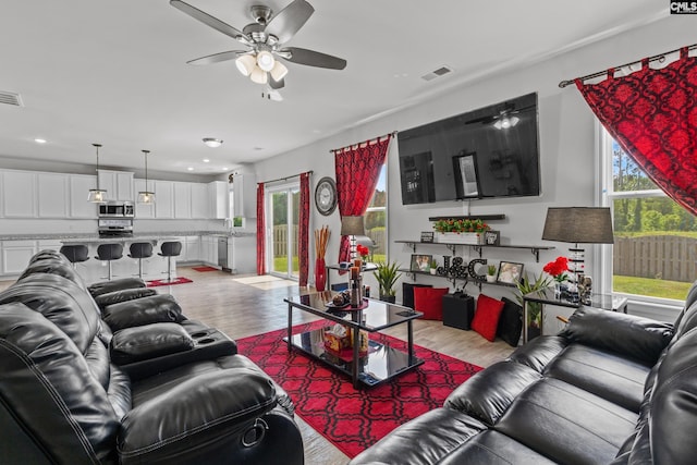 living room featuring a ceiling fan, recessed lighting, light wood finished floors, and visible vents