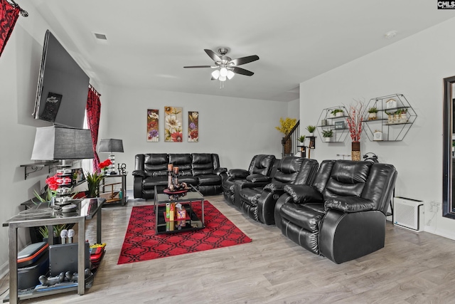 living room with baseboards, a ceiling fan, wood finished floors, and visible vents