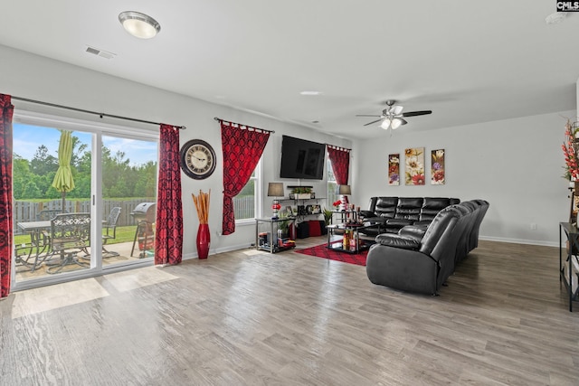 living area with baseboards, visible vents, ceiling fan, and wood finished floors