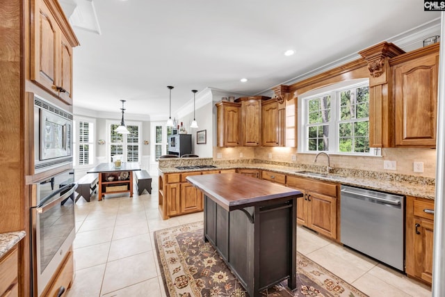 kitchen featuring ornamental molding, butcher block counters, a sink, backsplash, and stainless steel appliances