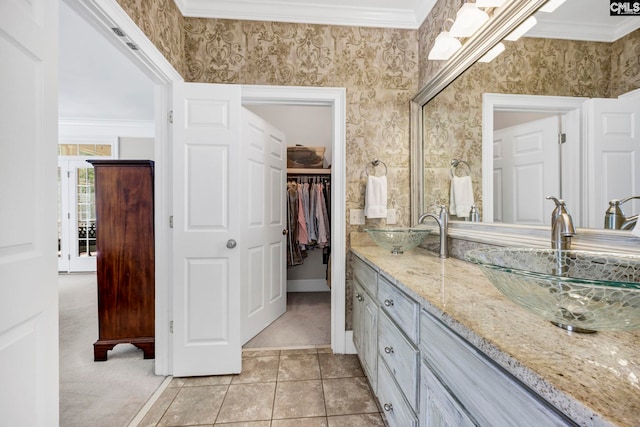 bathroom featuring double vanity, a sink, tile patterned flooring, and a spacious closet