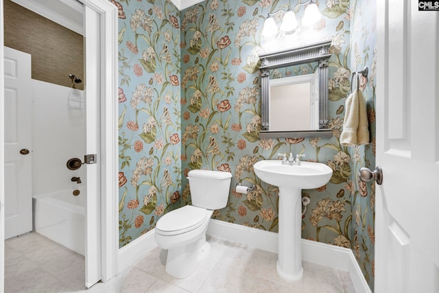 bathroom with tile patterned flooring, toilet, baseboards, wallpapered walls, and shower / bath combination