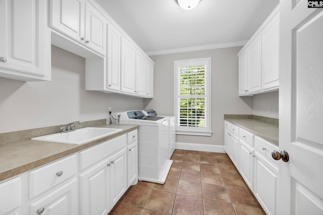 washroom featuring washing machine and clothes dryer, crown molding, tile patterned flooring, cabinet space, and a sink