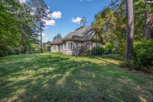 rear view of house featuring a lawn