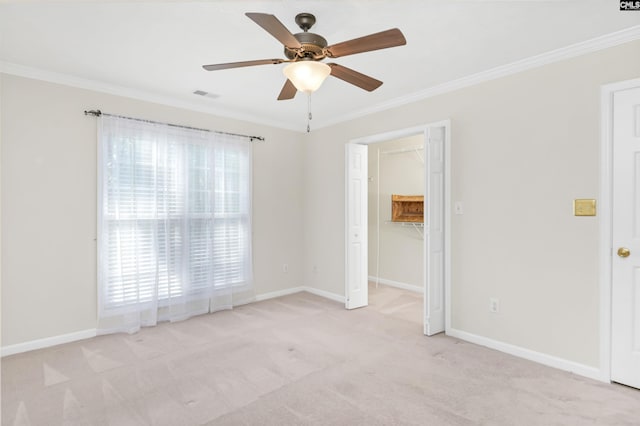 unfurnished room with visible vents, ornamental molding, baseboards, and ceiling fan