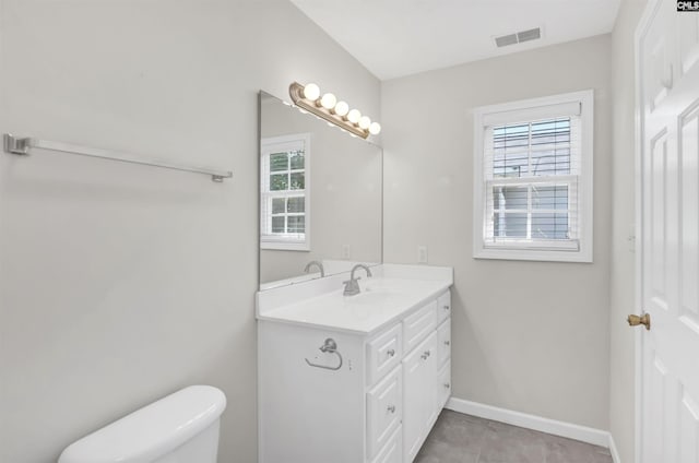 bathroom with visible vents, baseboards, tile patterned floors, vanity, and toilet