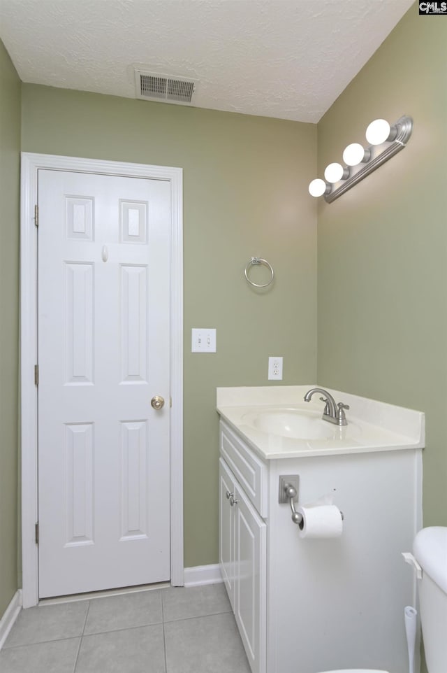 bathroom featuring a textured ceiling, visible vents, tile patterned floors, baseboards, and toilet