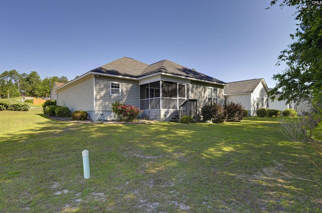 rear view of property featuring a sunroom and a yard