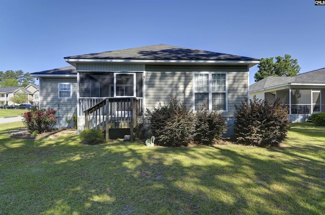 bungalow-style house featuring roof with shingles, a sunroom, and a front yard