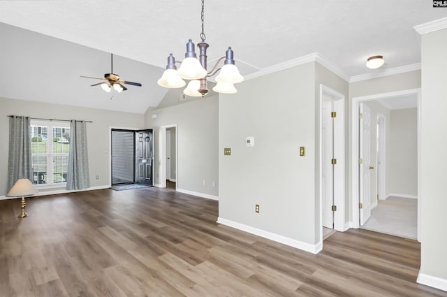 spare room featuring crown molding, lofted ceiling, wood finished floors, baseboards, and ceiling fan with notable chandelier