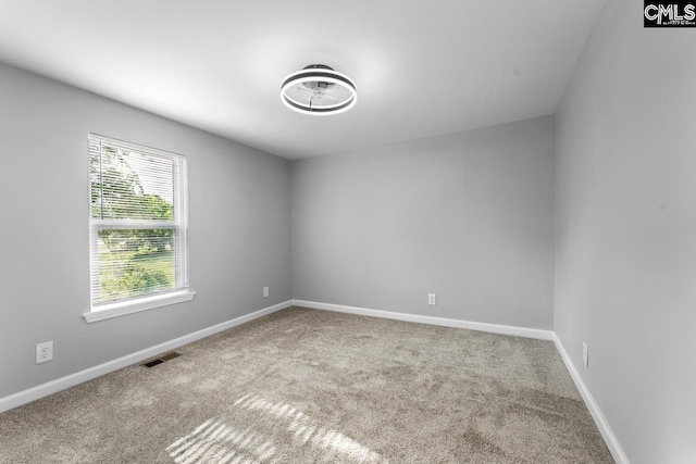 carpeted spare room featuring visible vents and baseboards