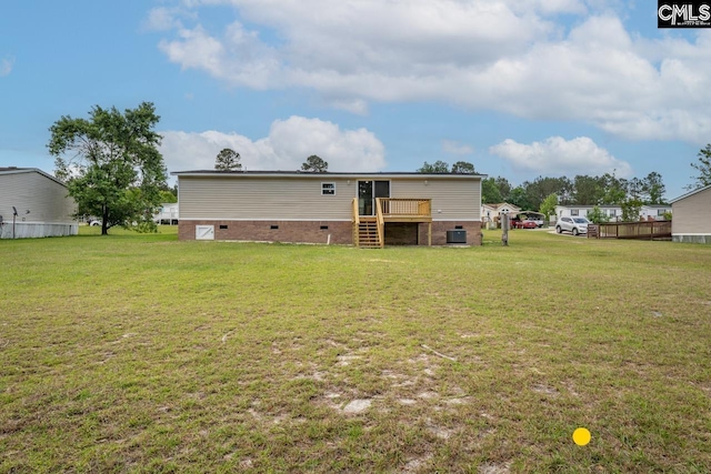 back of house featuring crawl space, a wooden deck, a yard, and stairway