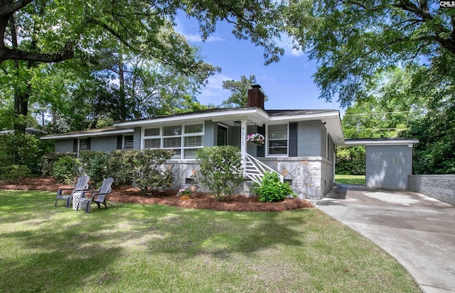 ranch-style home featuring a chimney, stone siding, and a front yard
