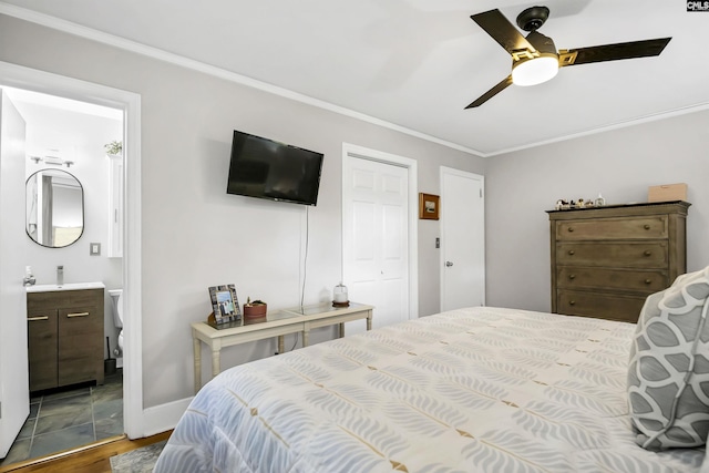 bedroom with crown molding, a ceiling fan, ensuite bath, and wood finished floors