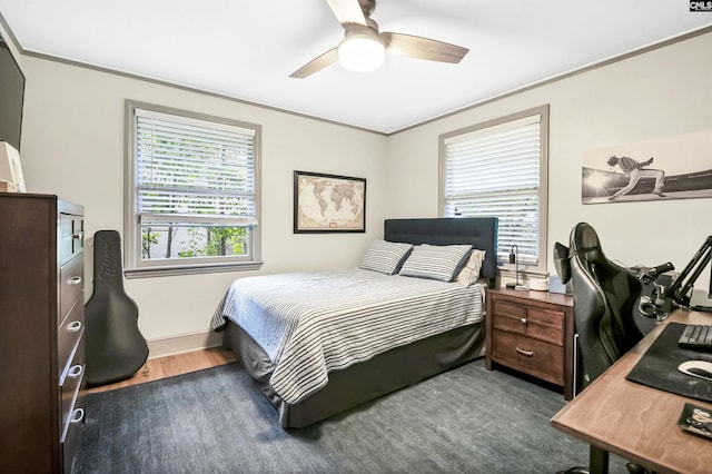 bedroom featuring baseboards, ornamental molding, a ceiling fan, and wood finished floors
