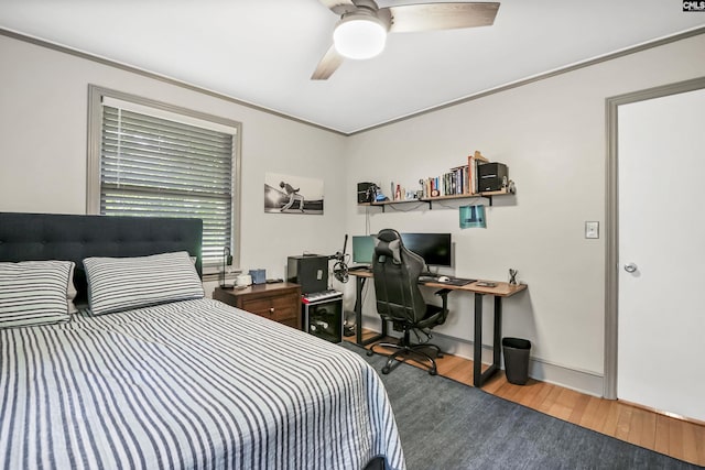bedroom with baseboards, ceiling fan, ornamental molding, and wood finished floors