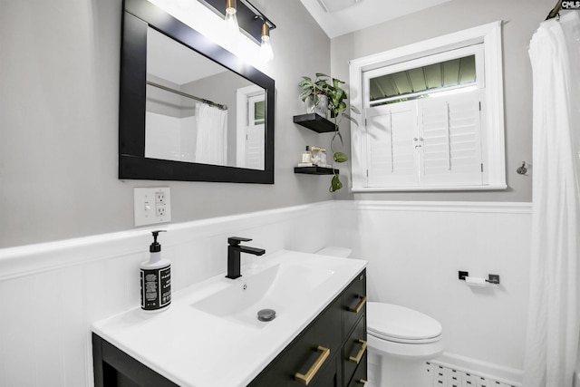 full bath featuring toilet, wainscoting, radiator heating unit, and vanity