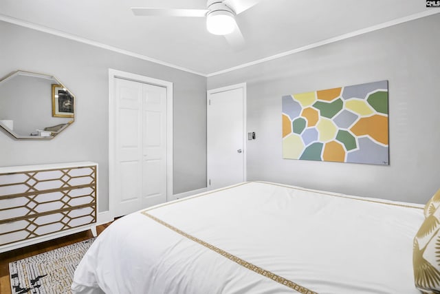 bedroom with crown molding, ceiling fan, wood finished floors, and a closet