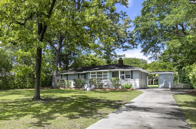 ranch-style house featuring a chimney, driveway, and a front yard
